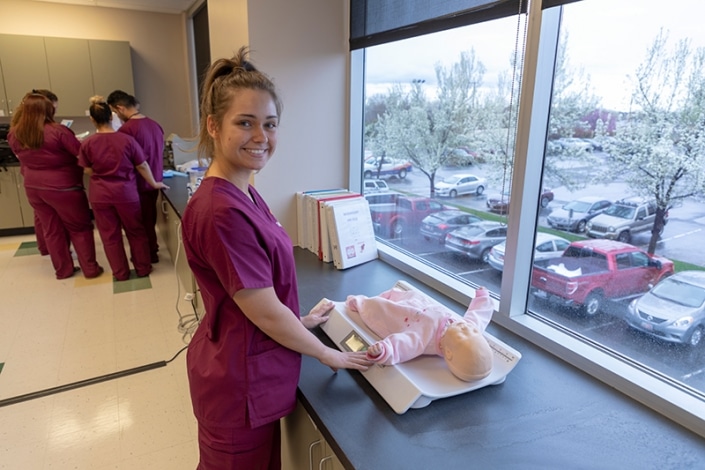 Student weighing a baby-sized testing dummy