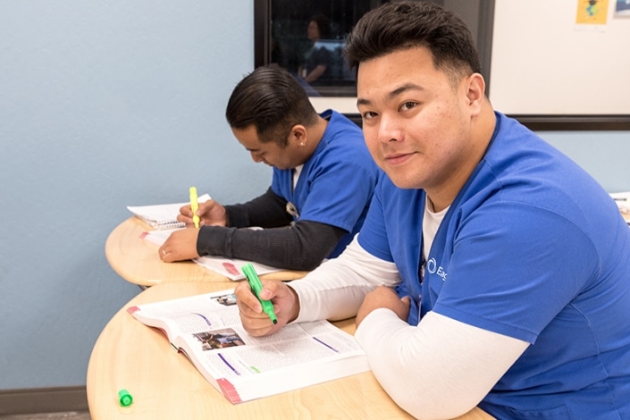 Nursing students studying from a textbook