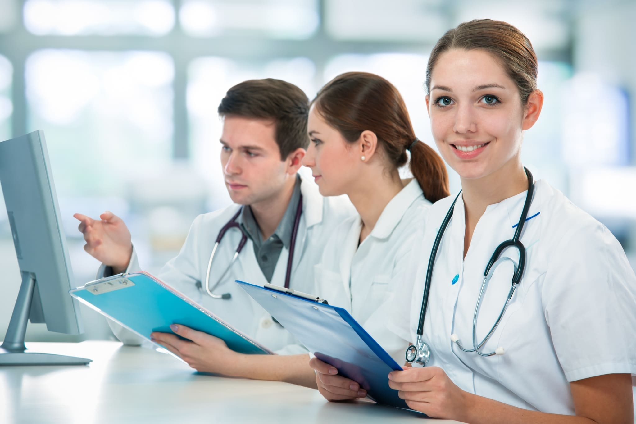 Smiling healthcare worker with a stethoscope and clipboard