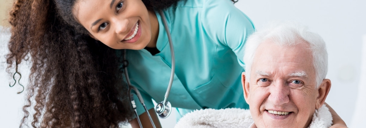 Smiling female caregiver with elderly man