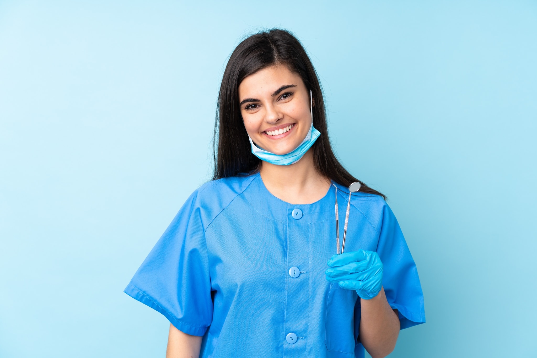 Smiling young dentist with instruments