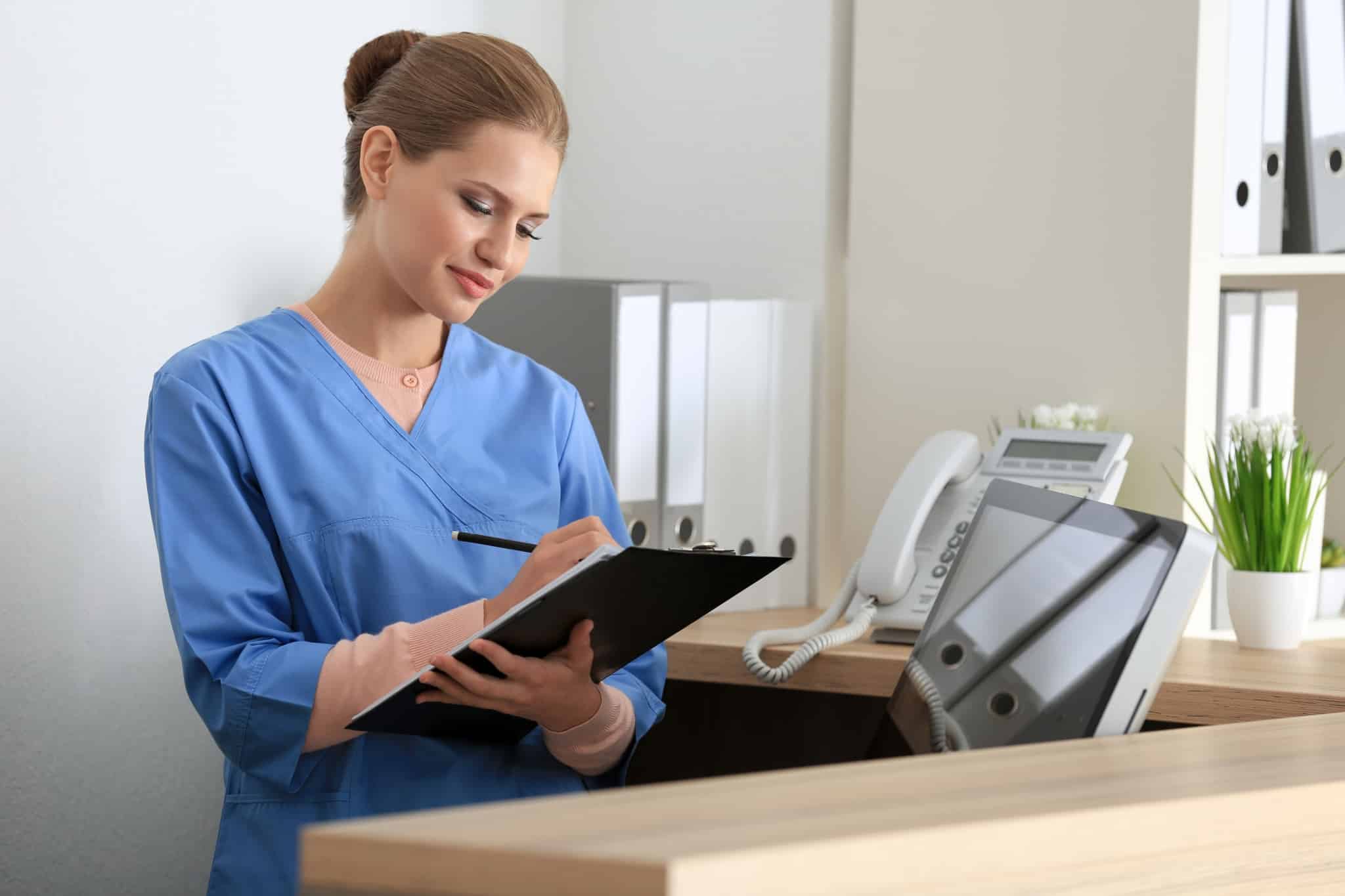 Female healthcare worker writing on a chart