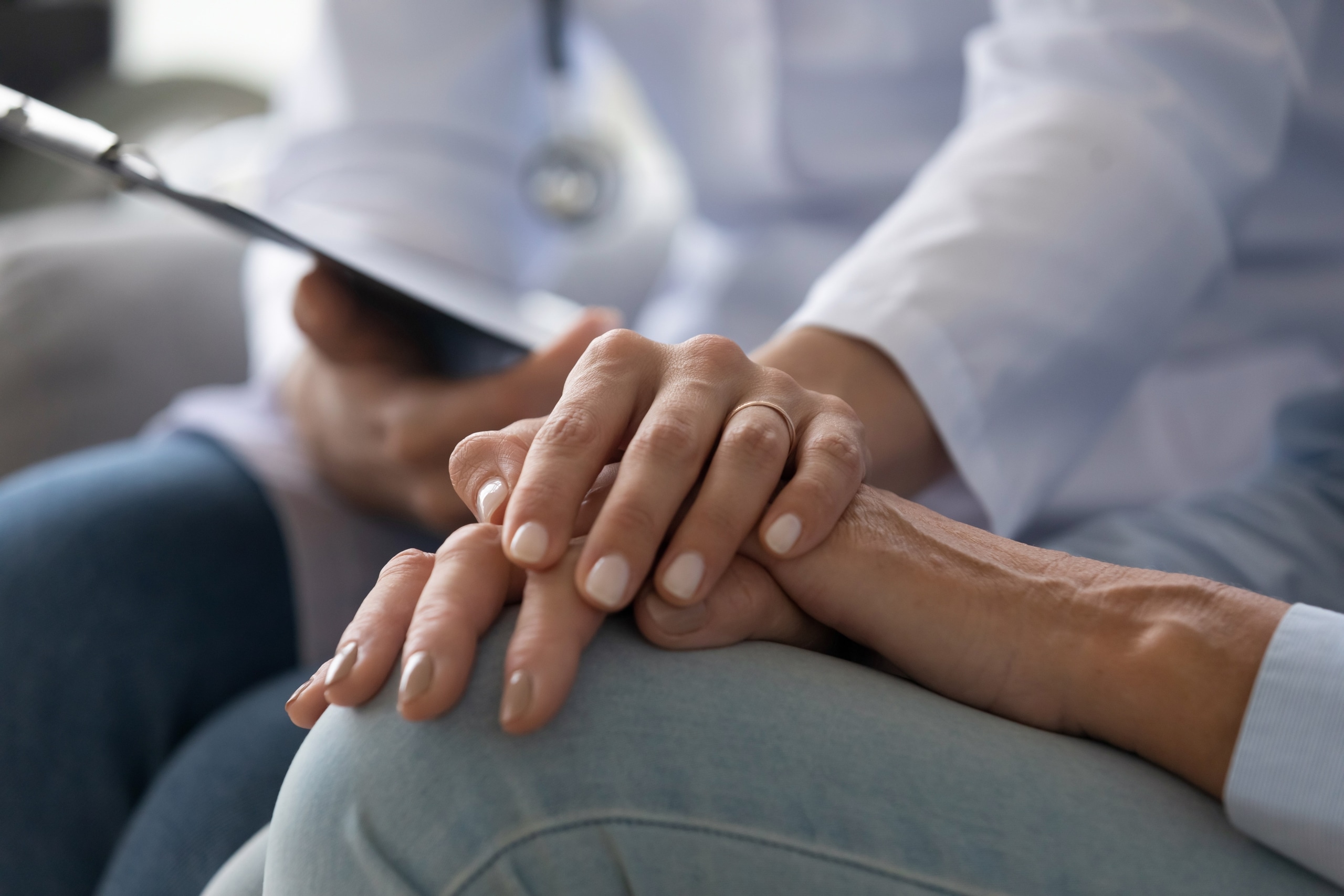 Nurse touching the hand of a patient