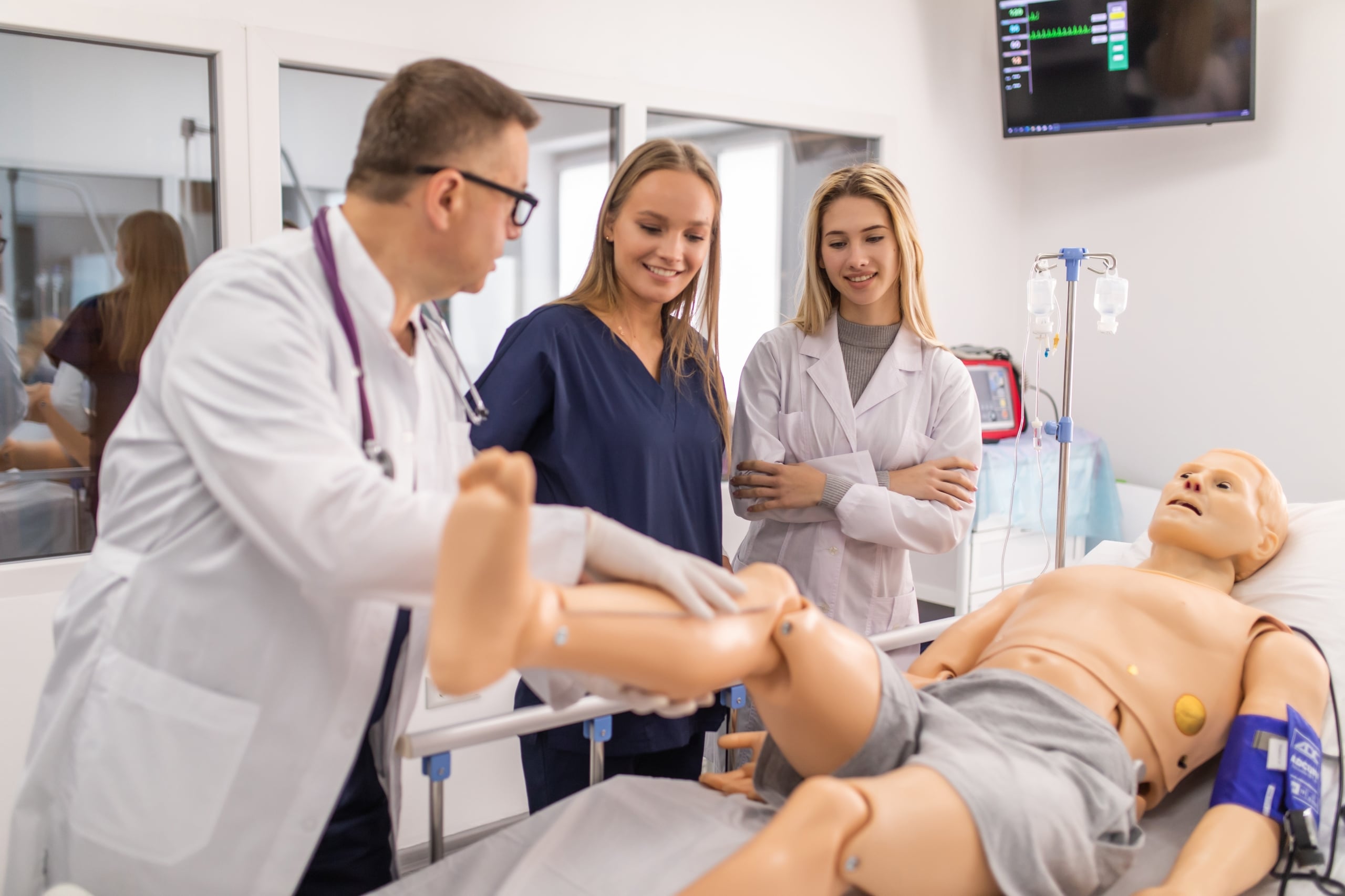 Smiling medical students with their instructor and a mannequin