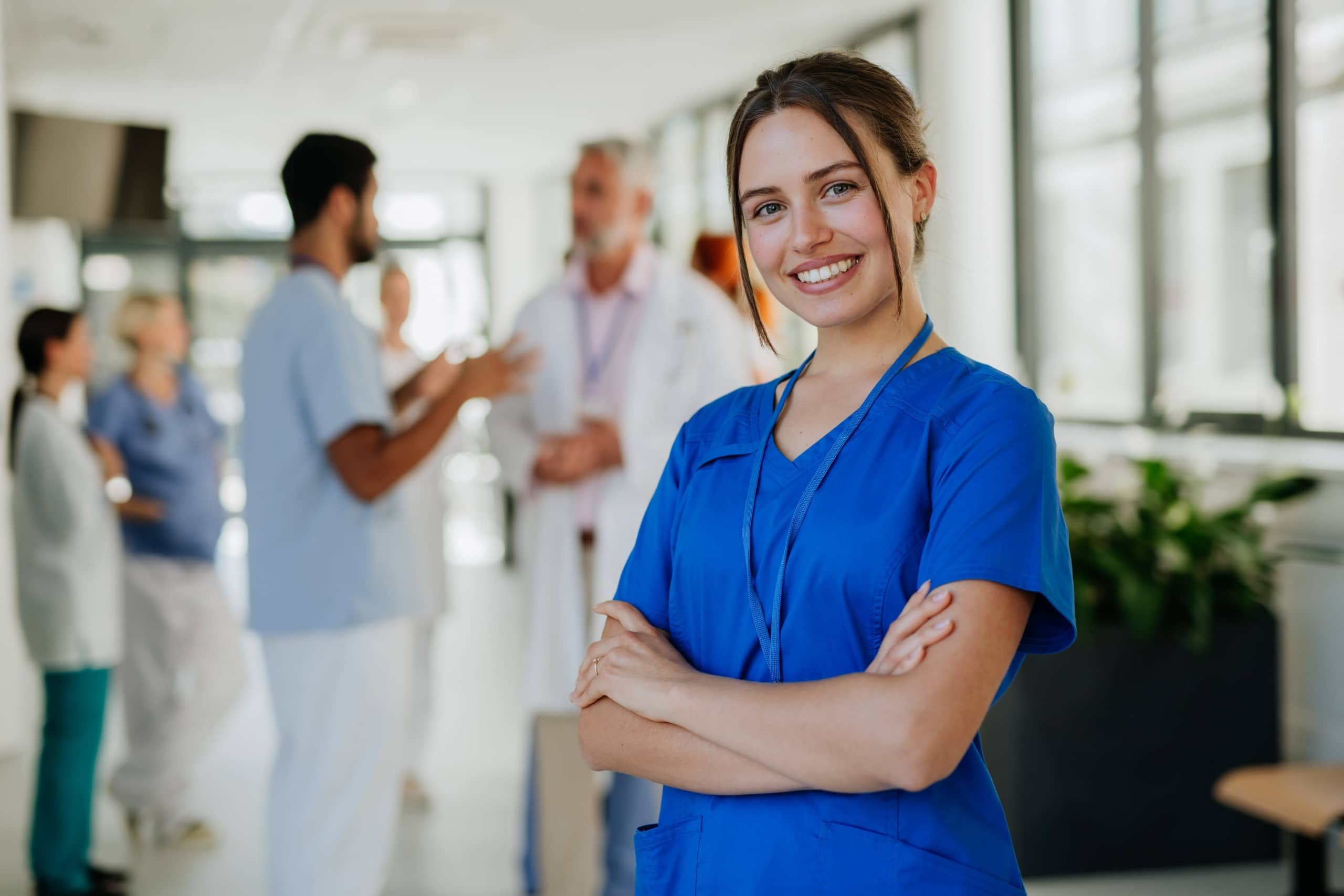 Young smiling nurse in front of other professionals