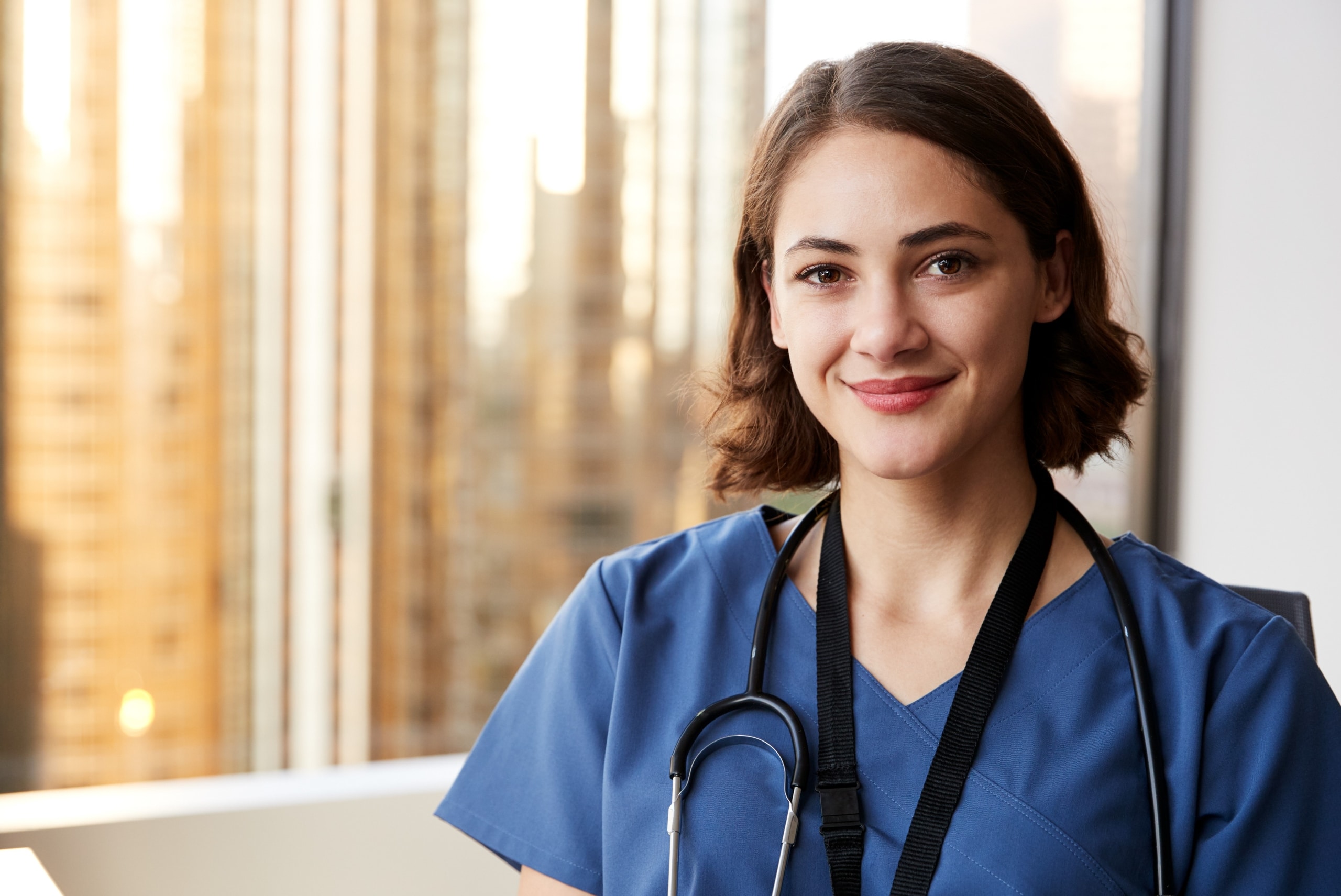 Close up of a smiling nurse in scrubs