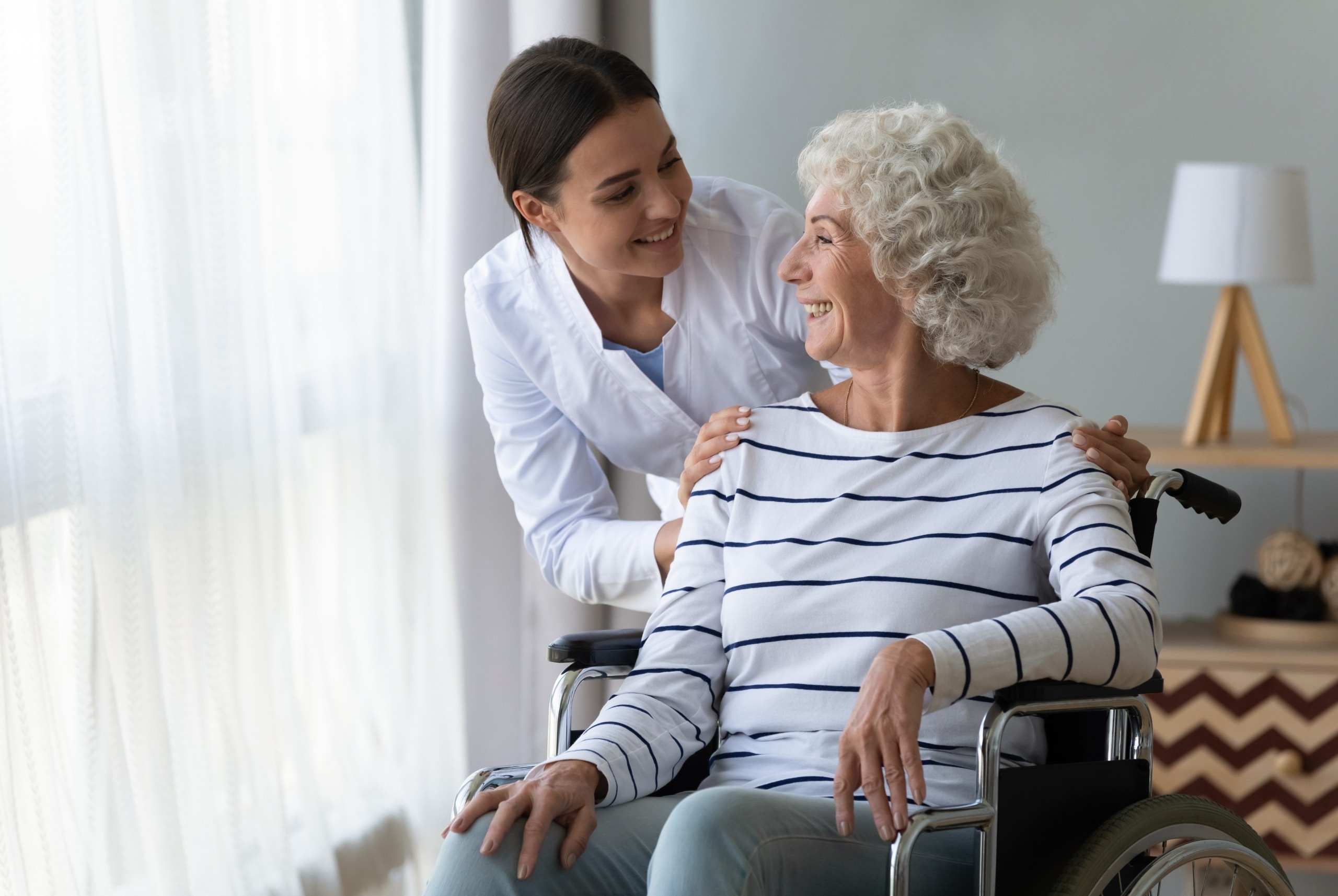 Medical professional assisting an elderly patient in a wheelchair