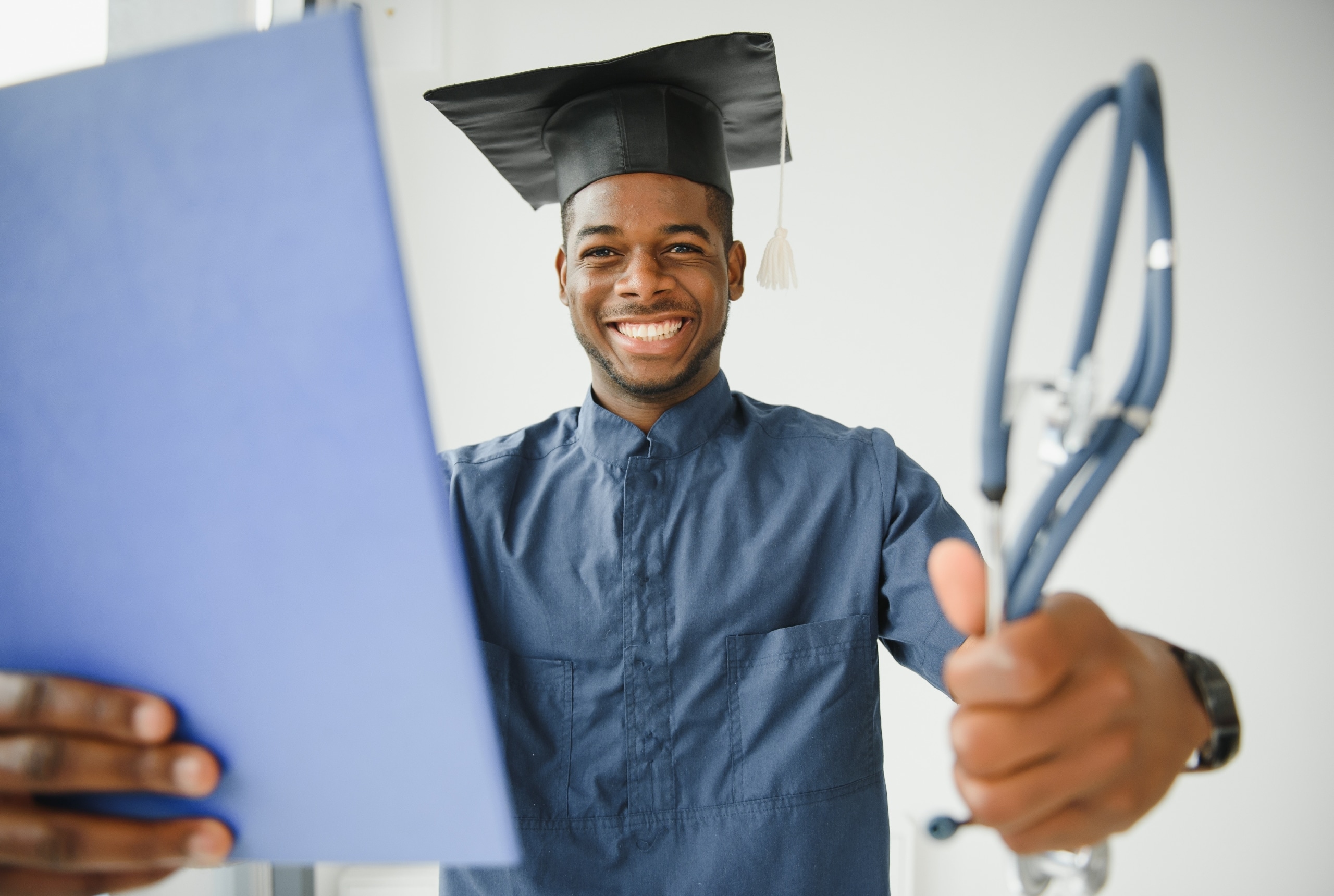 African-American nursing graduate holding a stethoscope