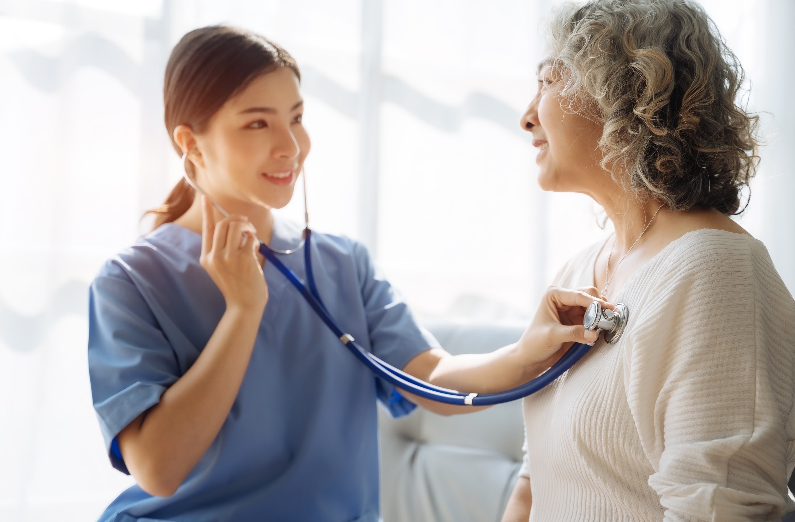 Asian nurse taking an elderly patient's heartbeat