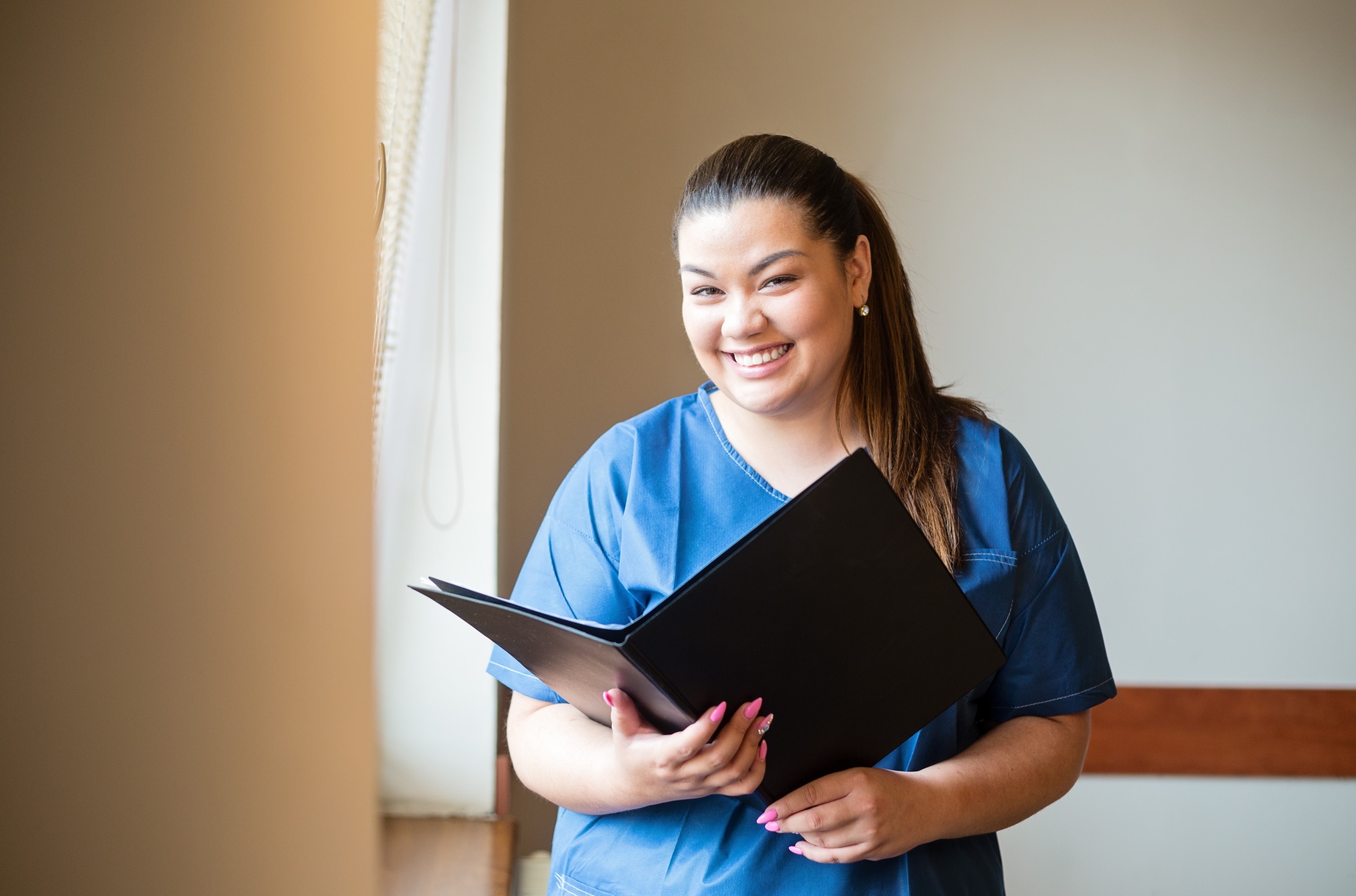Smiling nurse holding an open binder