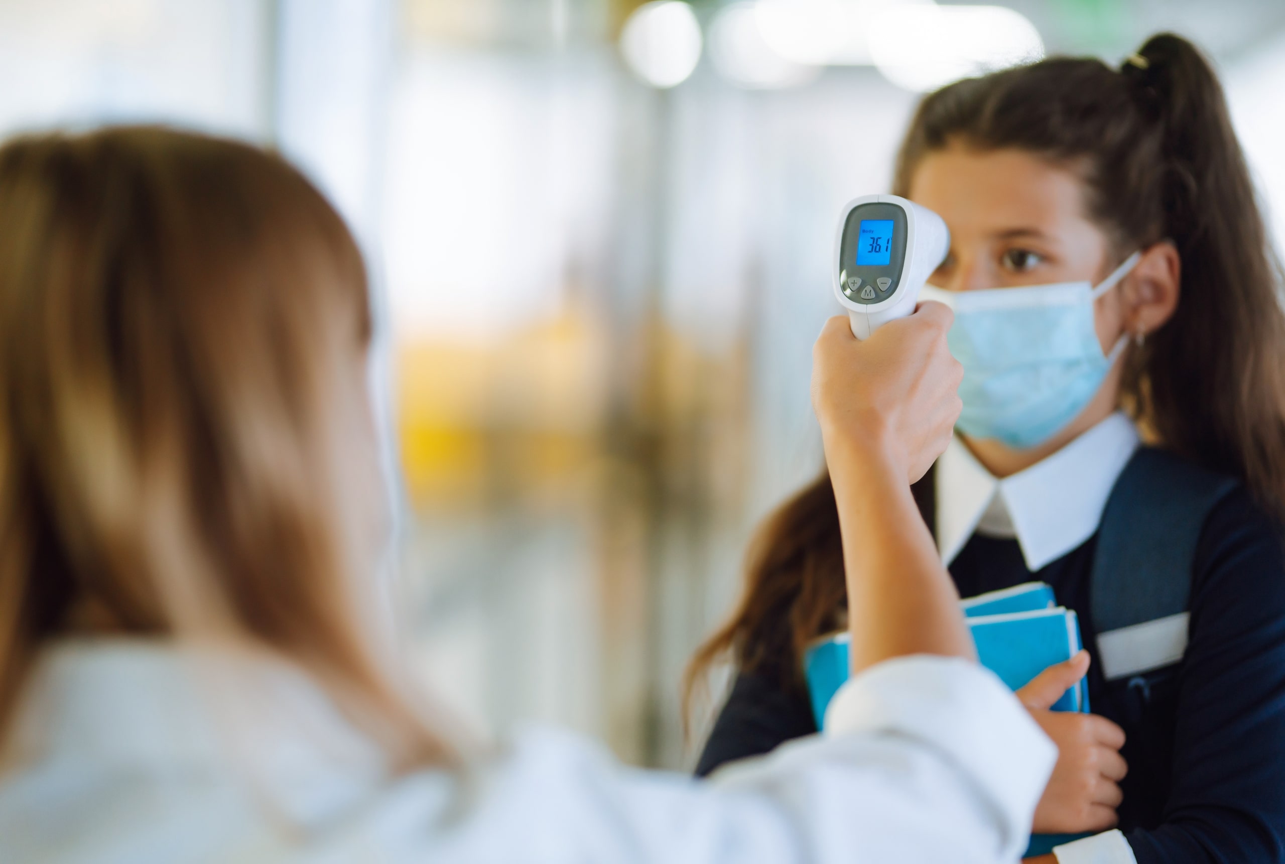 Close up of a school nurse taking a student's temperature