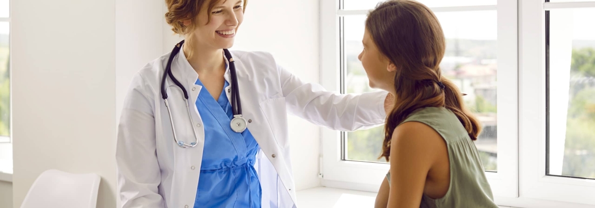 Smiling school nurse consoling a female student