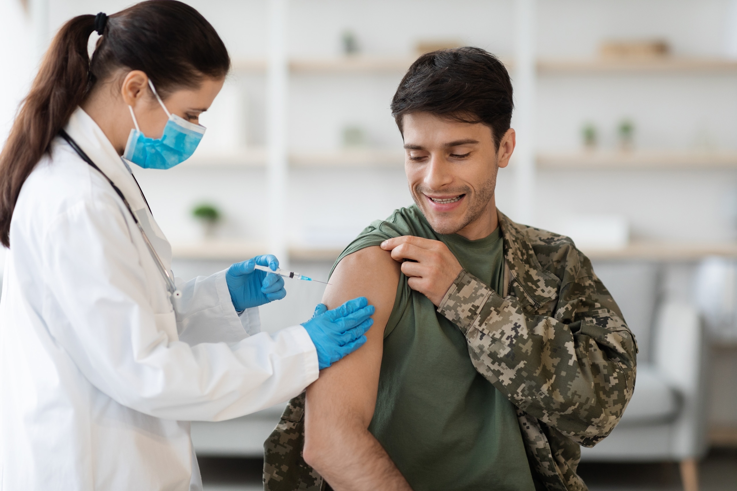 Medical professional giving military personnel a shot