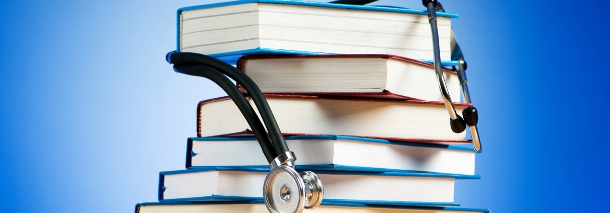 Stack of books with a stethoscope draped on top