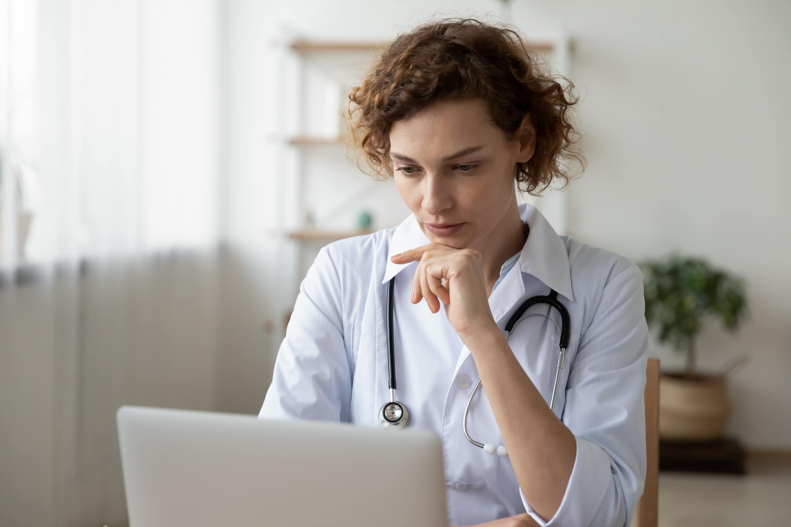 Nurse concentrating as she uses a laptop