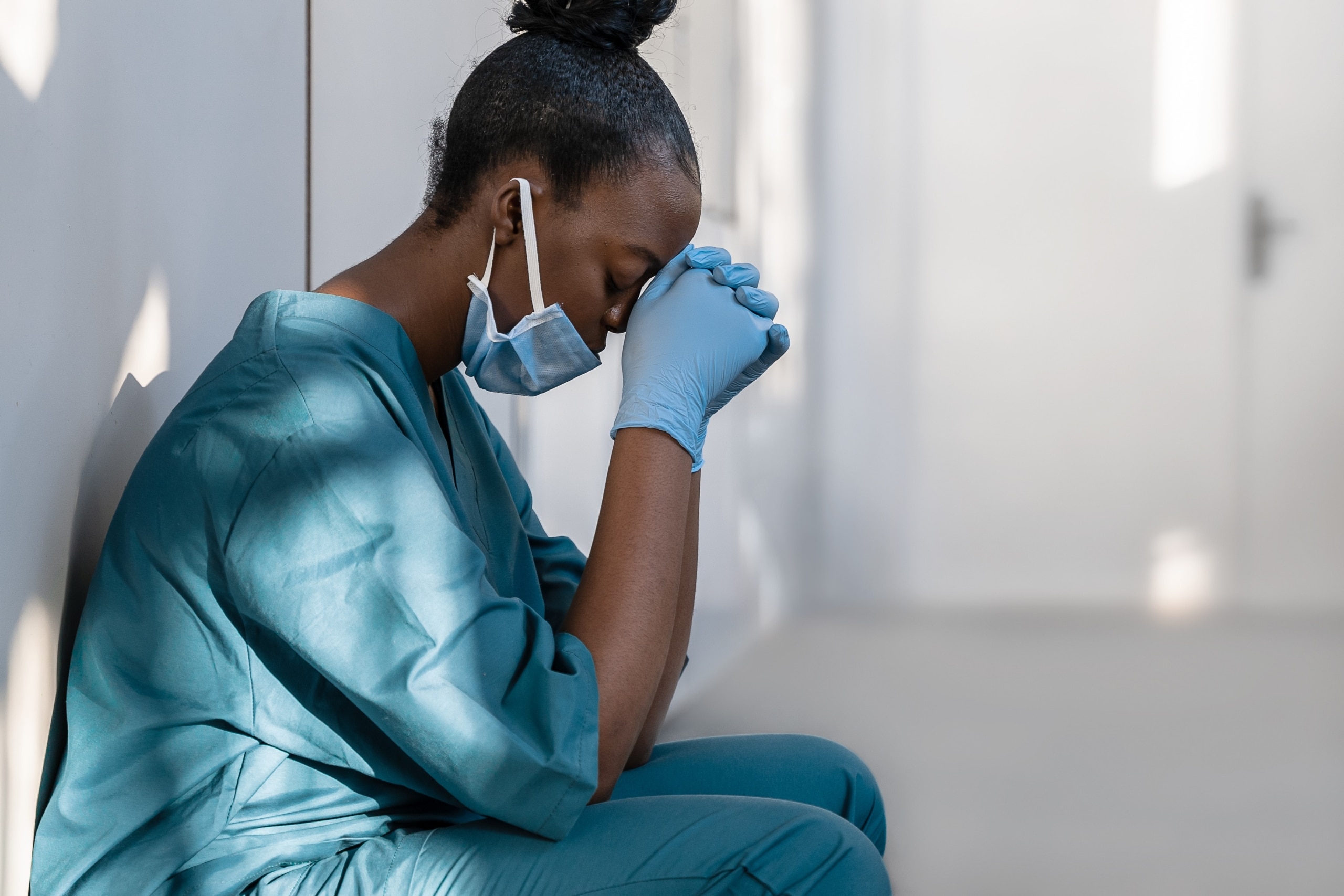African-American nurse resting her head on her hands