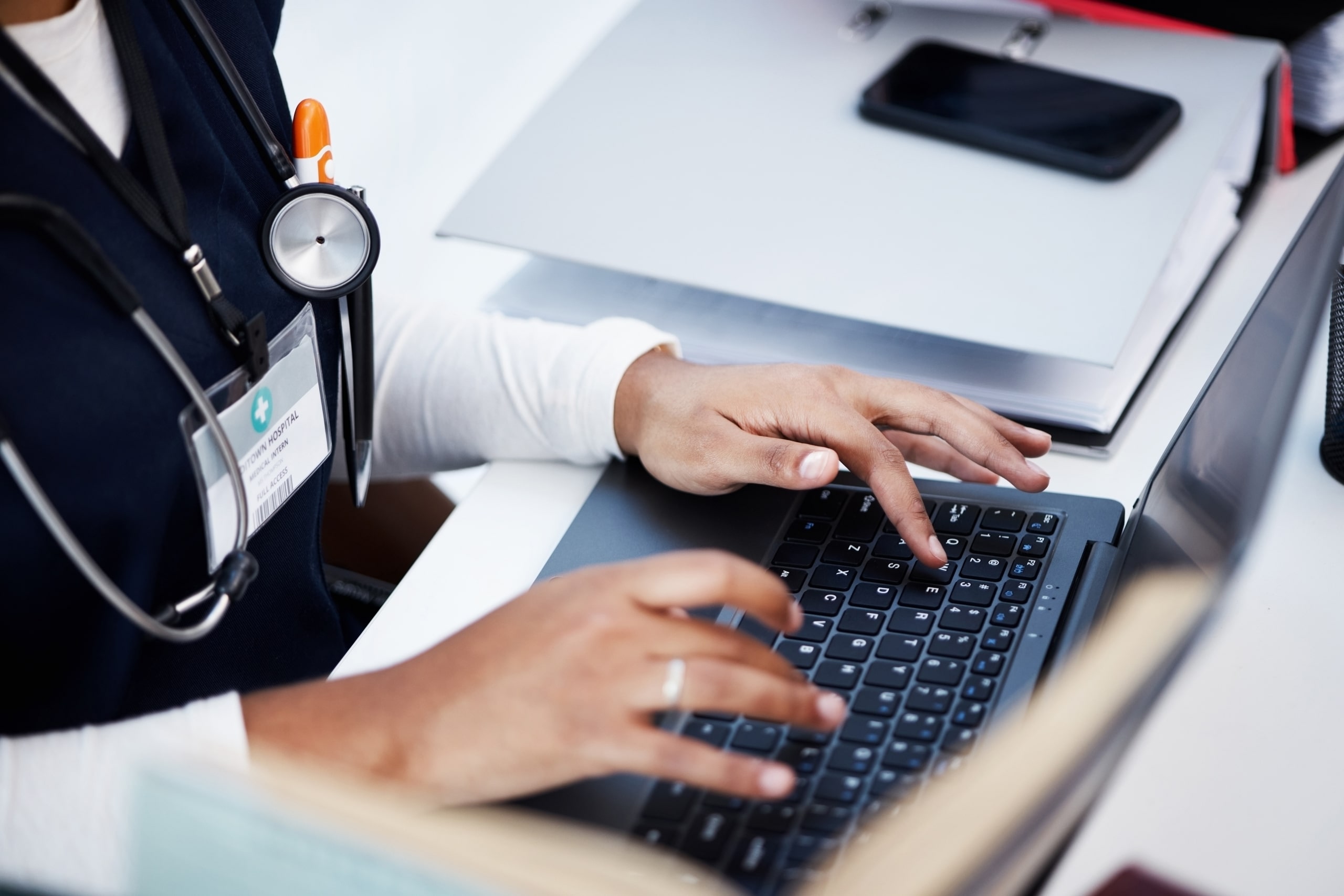 Close up of a medical professional typing on a computer