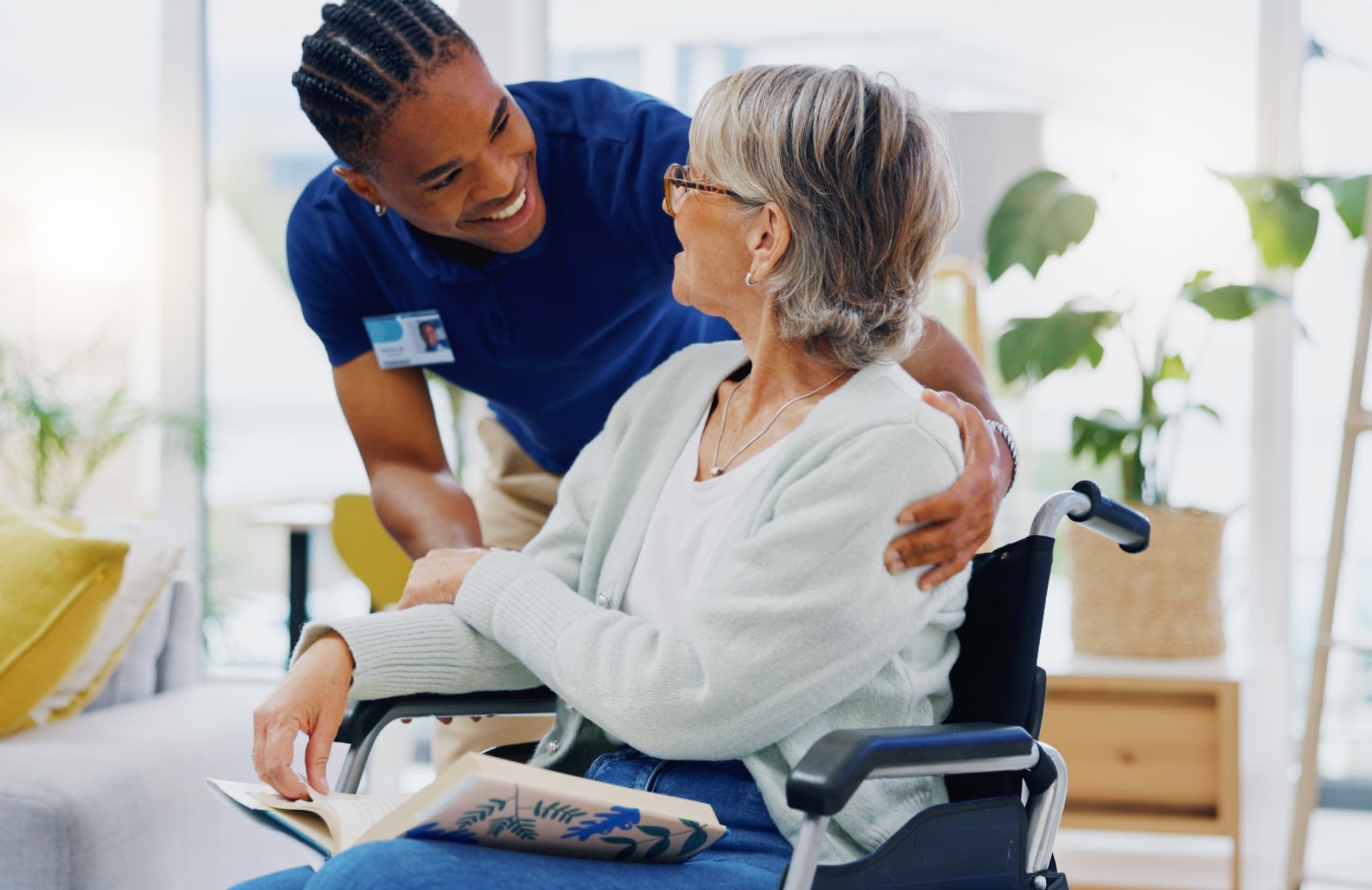 African-American male nurse speaking with a woman in a wheelchair