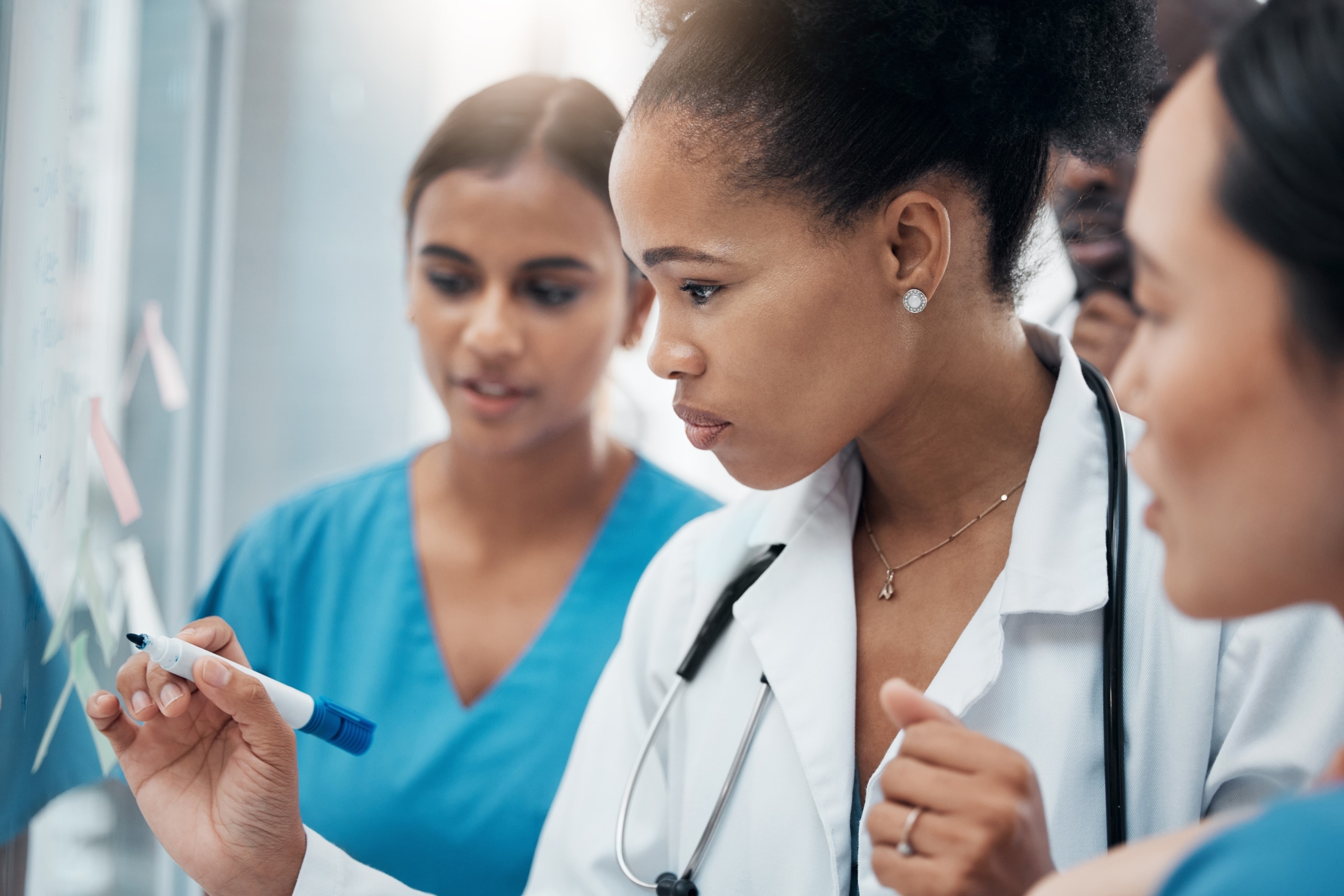 African-American medical professionals writing on a whiteboard