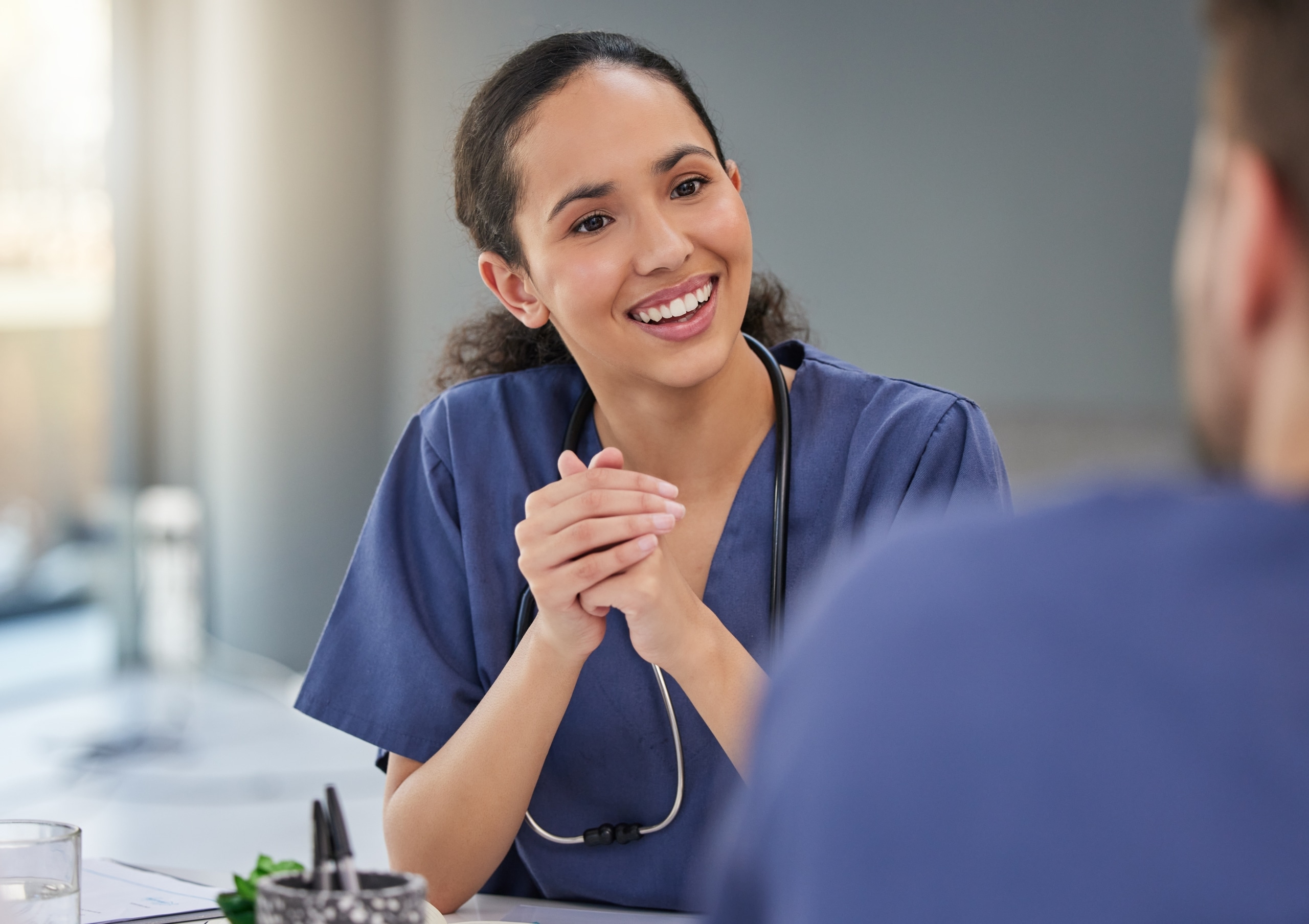 Diverse medical professionals in scrubs smiling at each other