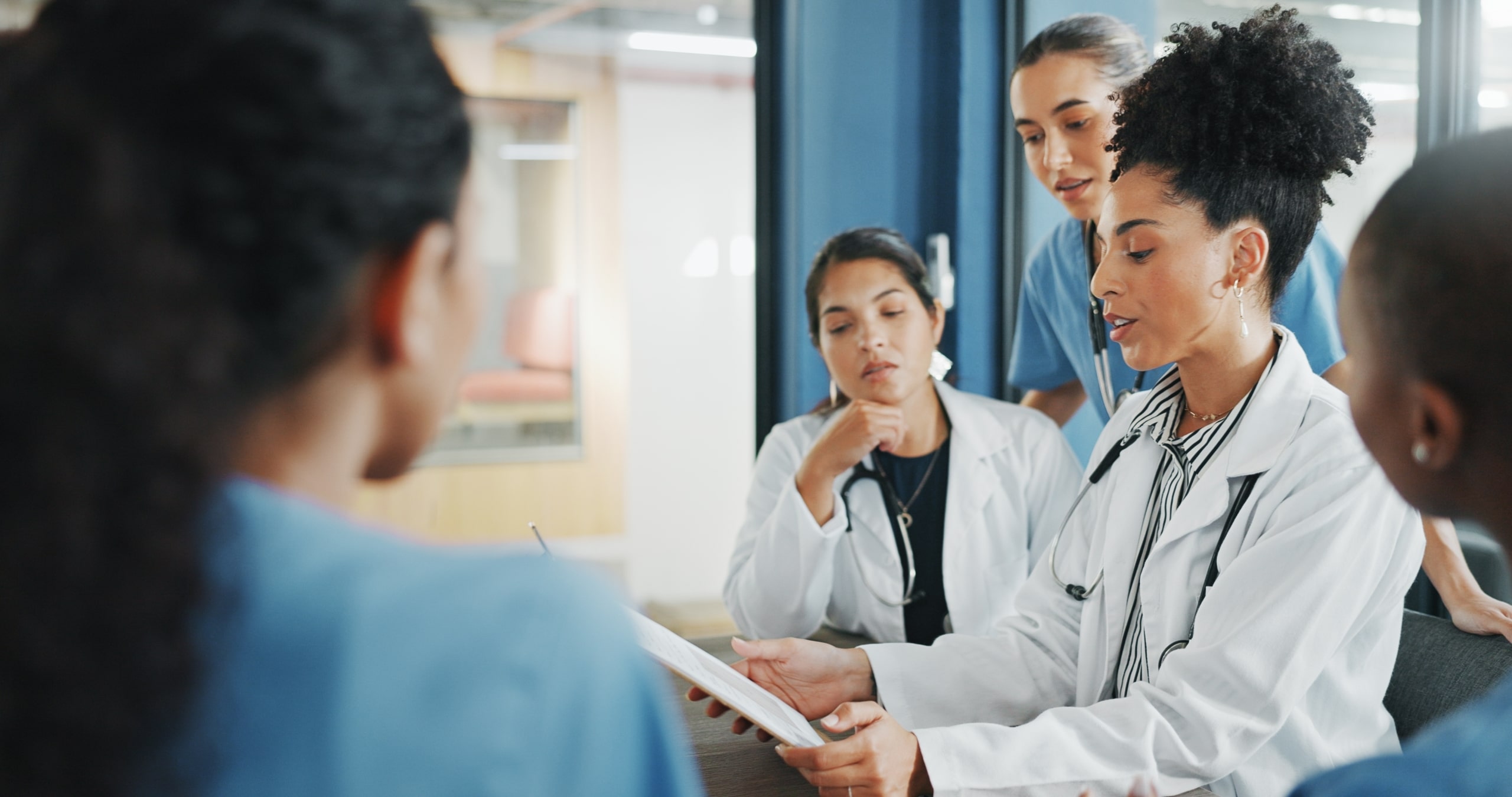 Team of medical professionals gathered around an African-American professional