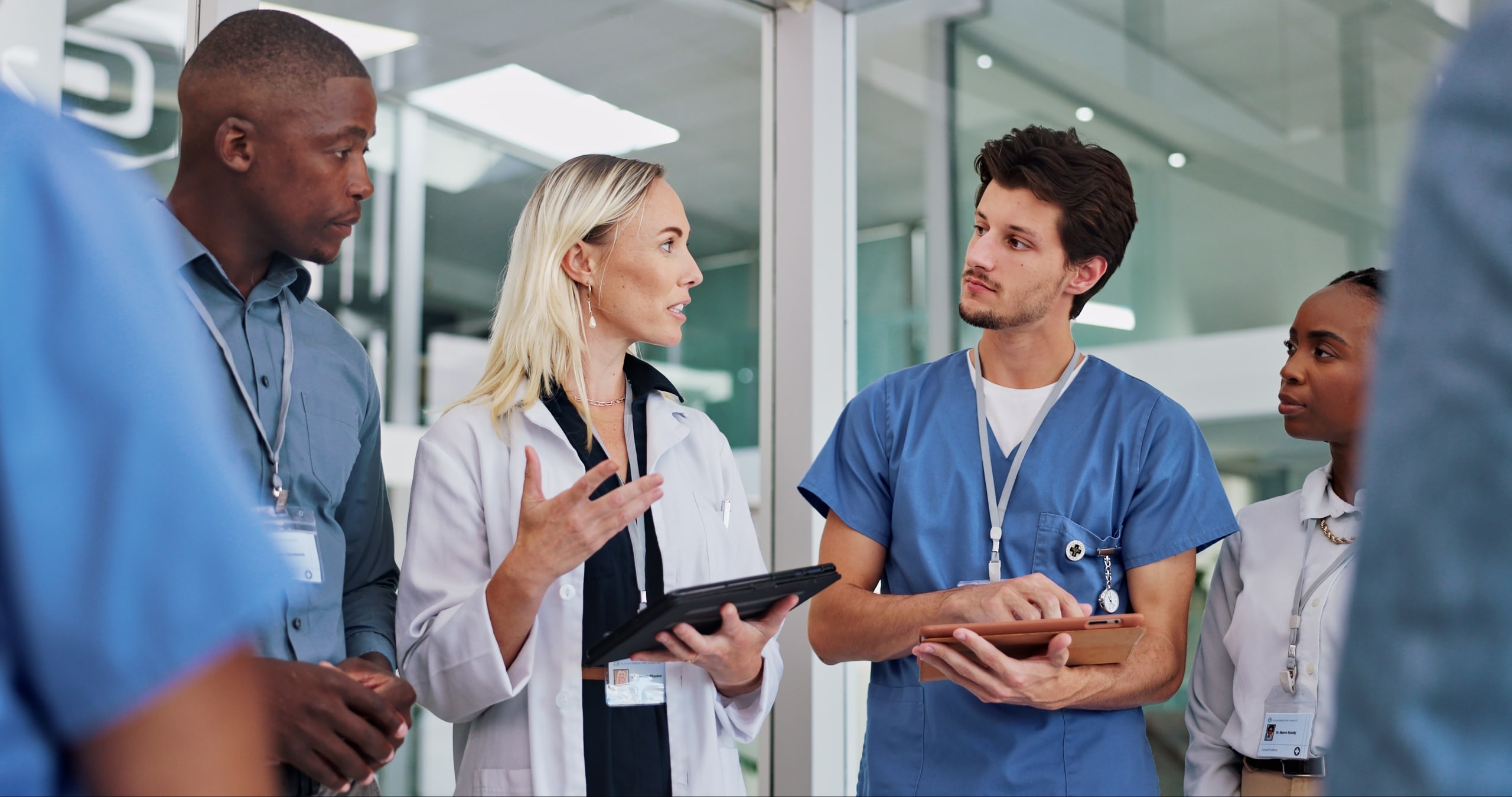 Group of diverse medical professionals speaking in a hallway