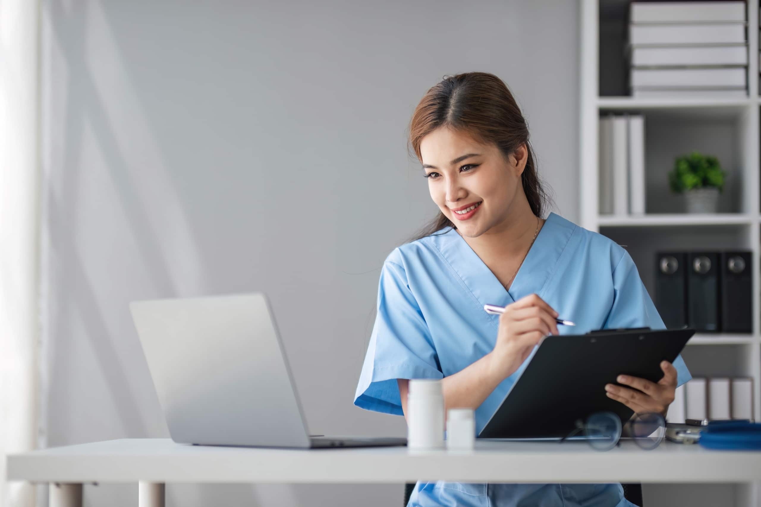 Beautiful Asian nurse using a laptop