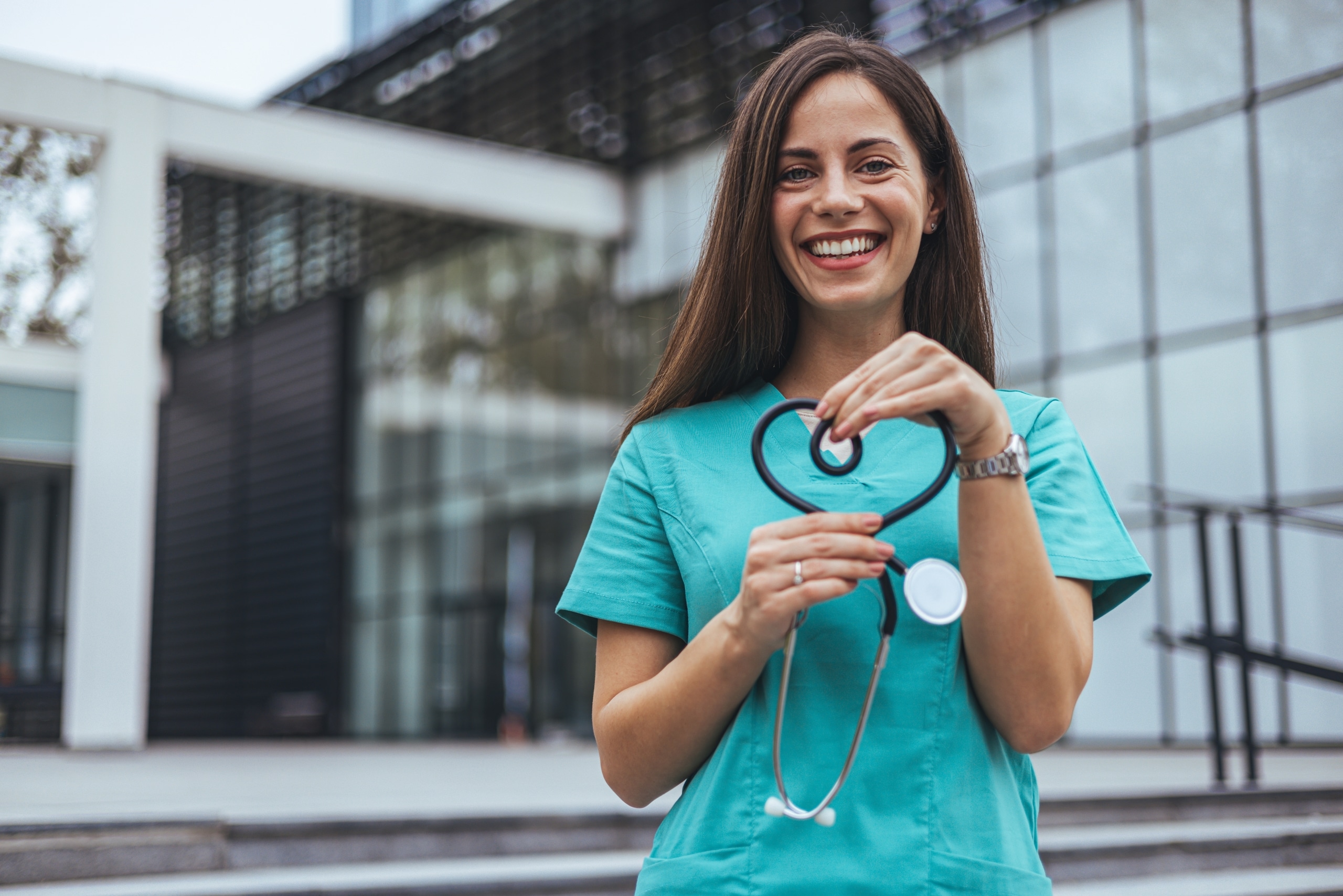 Smiling nurse forming a heart with her stethoscope