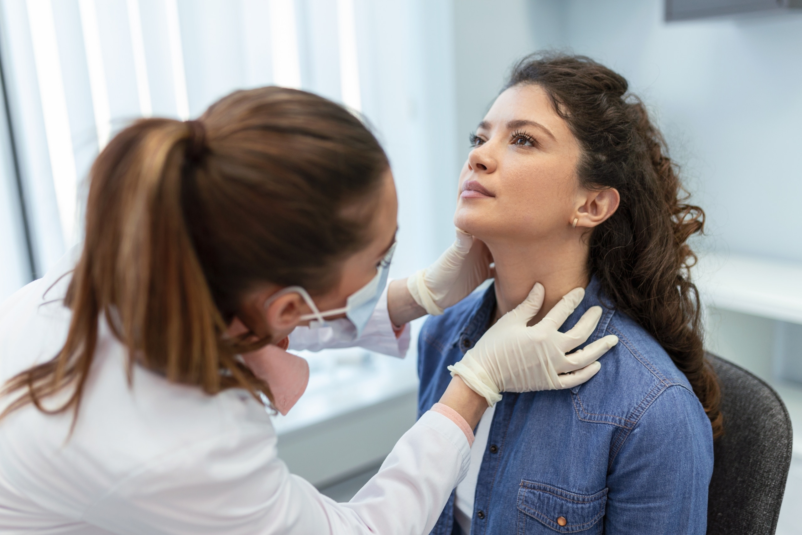 Medical professional examining a patient's neck
