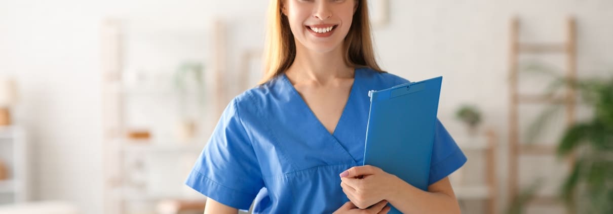 Female medical professional standing in a clinic with a patient's chart