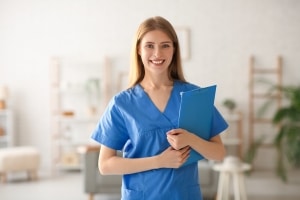 Female medical professional standing in a clinic with a patient's chart