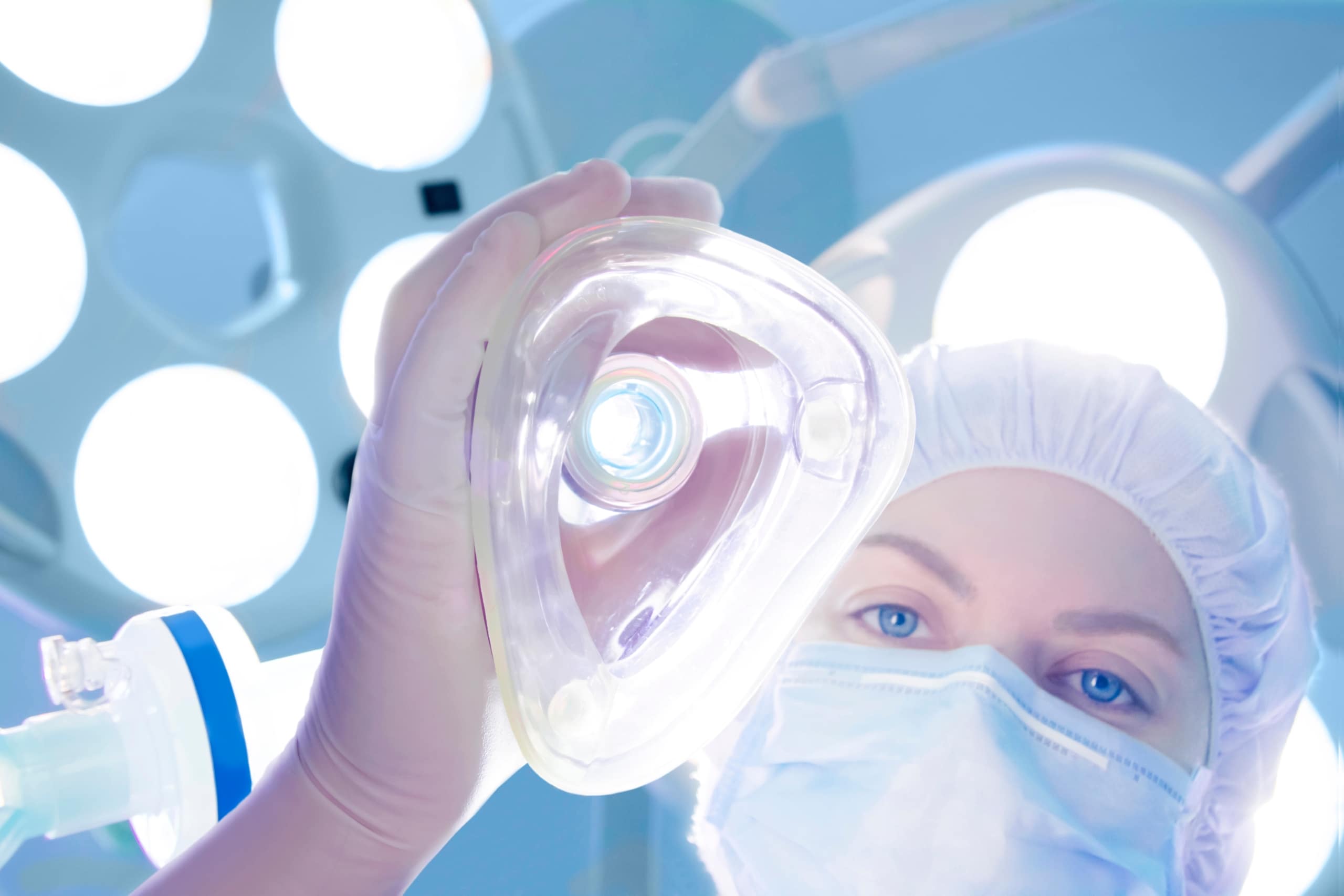 Anesthesiologist holding a mask over a patient's face