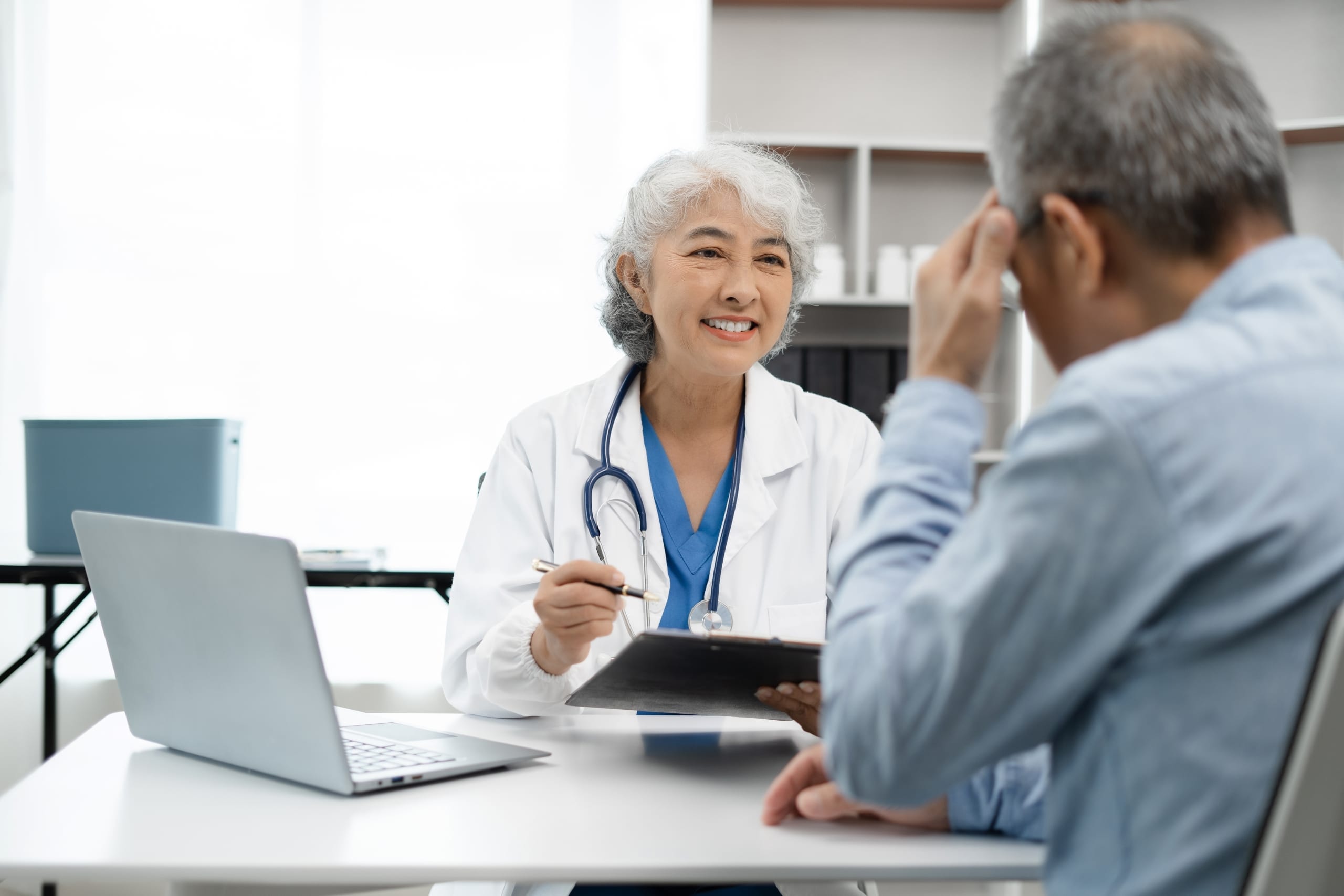 Asian medical professional speaking with an older man