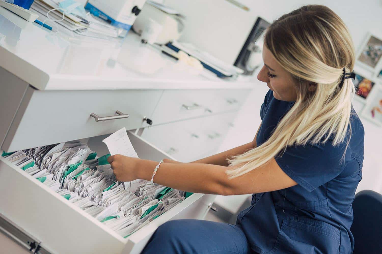 Female medical professional filing documents in a drawer