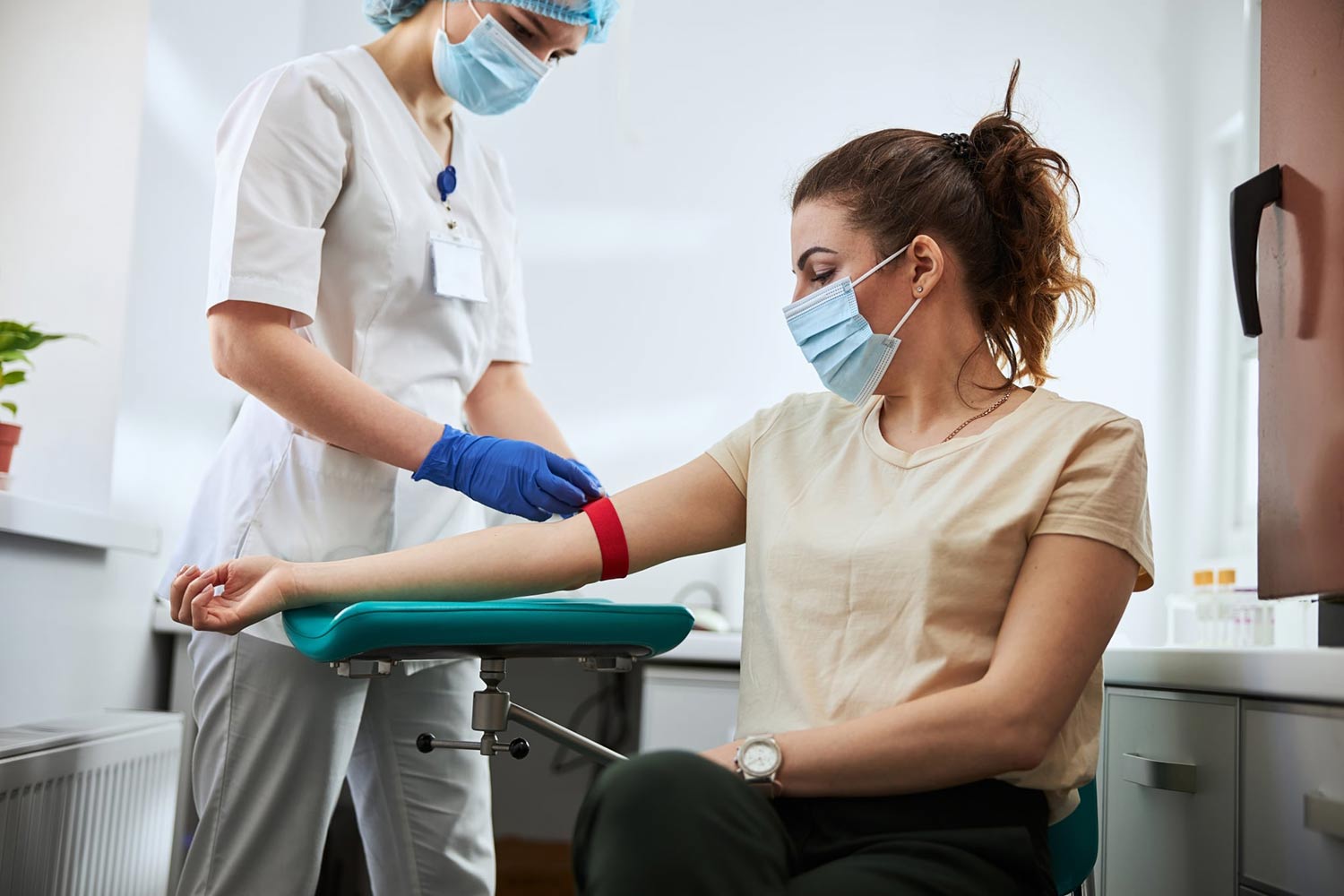 Phlebotomist drawing blood from a female patient