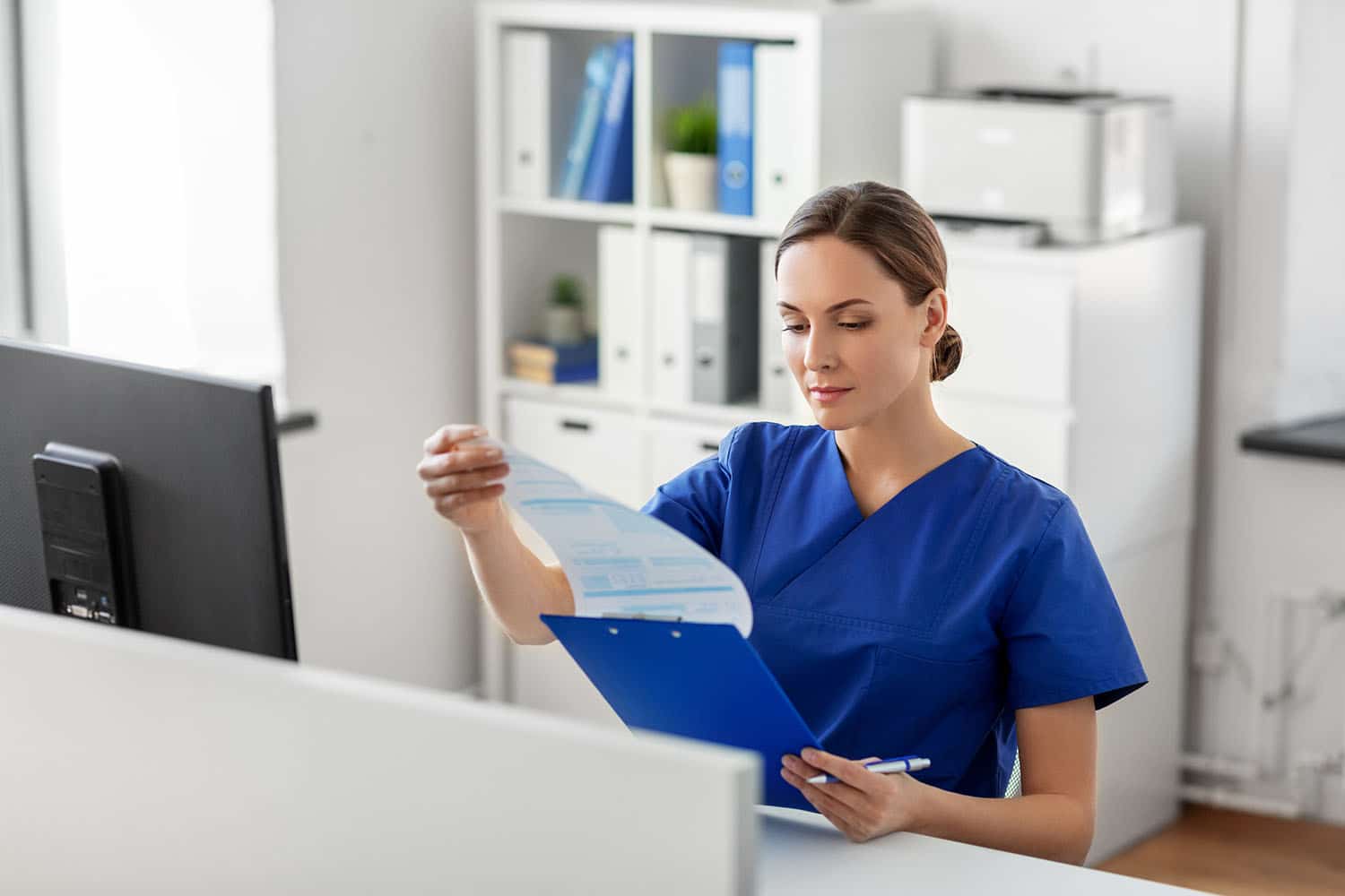 Beautiful nurse reading a patient's chart