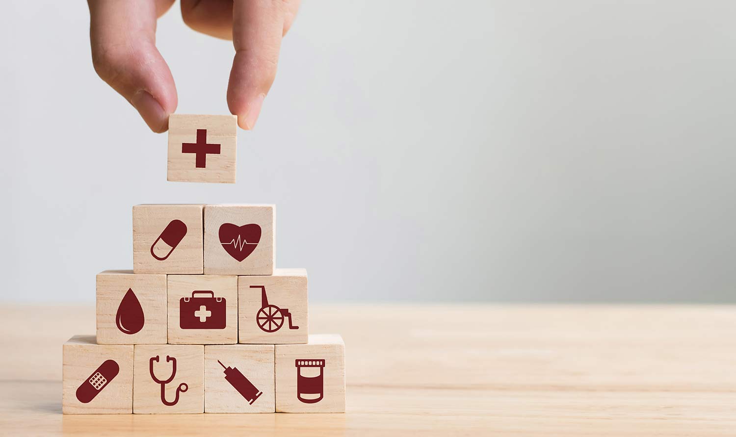 Close up of a person stacking blocks with healthcare symbols