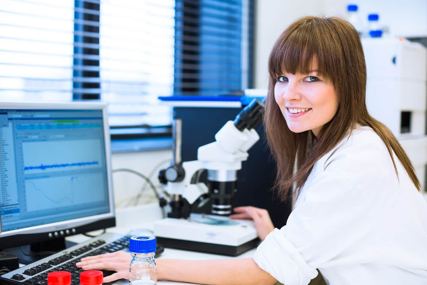 Beautiful nurse researcher in a lab using a computer